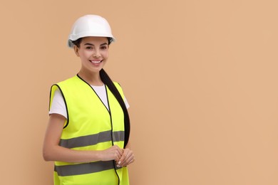 Photo of Engineer in hard hat on beige background, space for text