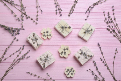 Hand made soap bars with lavender flowers on pink wooden table, flat lay