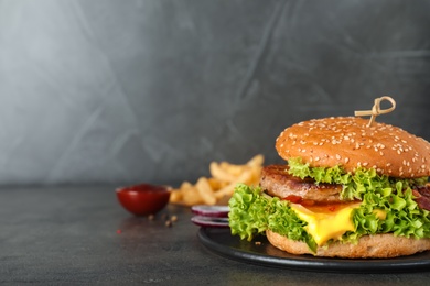 Plate with tasty burger on table. Space for text