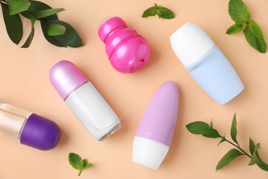 Photo of Flat lay composition with different female roll-on deodorants on beige background
