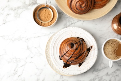 Flat lay composition with cinnamon roll and space for text on marble background