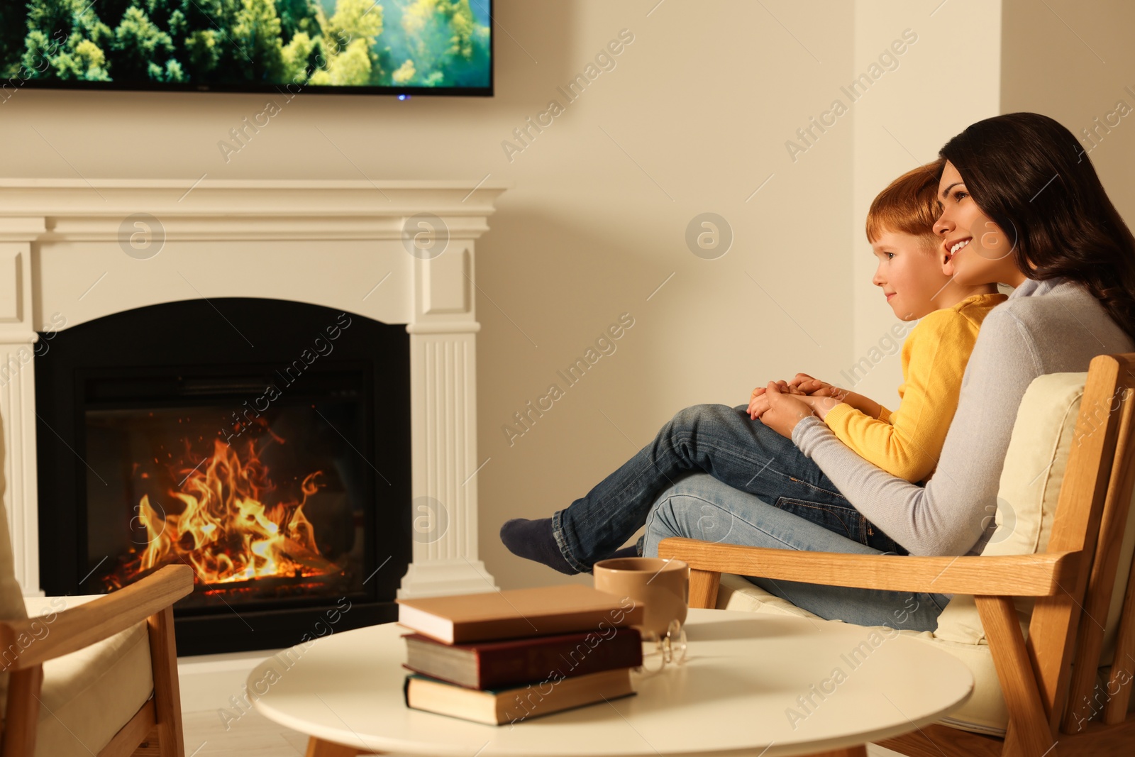 Photo of Happy mother and son spending time together near fireplace at home