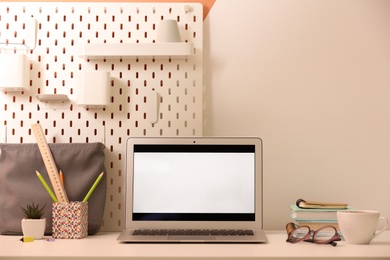 Modern laptop and stationery on table in office