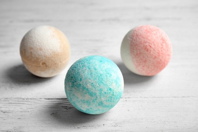 Photo of Colorful bath bombs on white wooden background