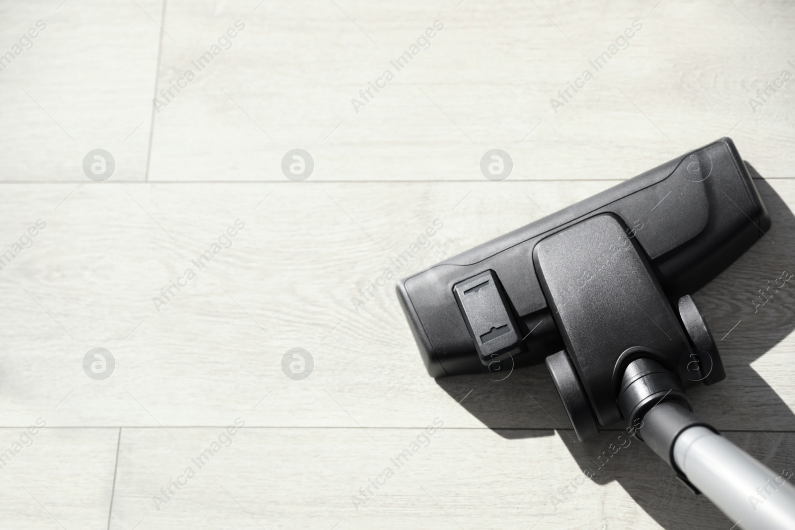 Photo of Modern vacuum cleaner indoors, closeup. Space for text