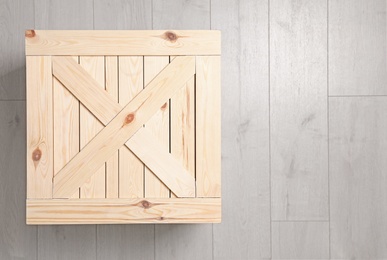 Photo of Wooden crate on floor, top view. Space for text