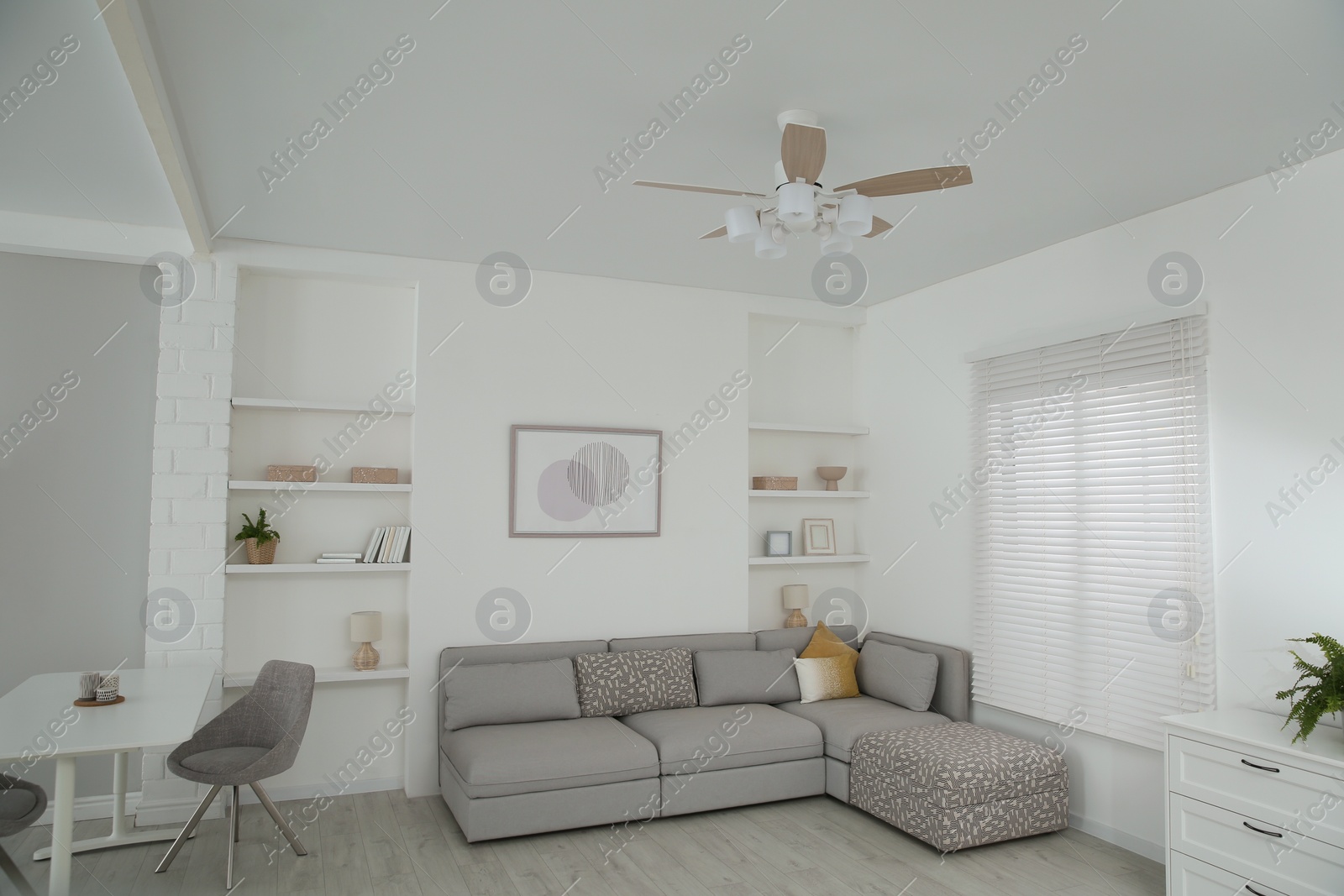 Photo of Comfortable furniture, ceiling fan and accessories in stylish living room