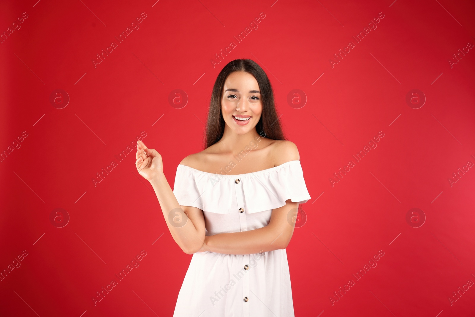 Photo of Young woman wearing stylish white dress on red background