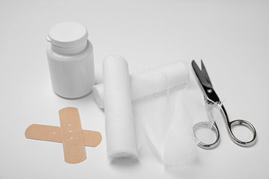 Photo of Bandage rolls and medical supplies on white background