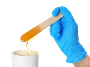Photo of Woman with wooden stick and sugaring paste on white background, closeup
