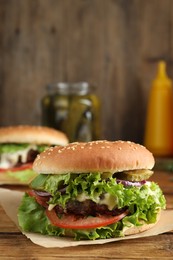 Photo of Delicious burger with beef patty and lettuce on wooden table, closeup