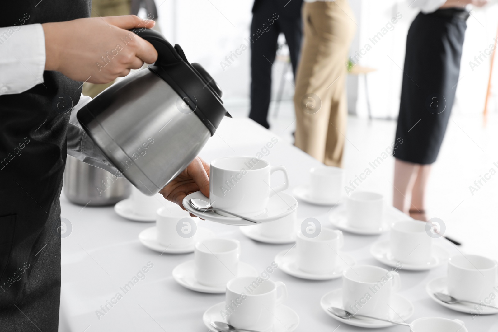 Photo of Waitress pouring hot drink during coffee break, closeup