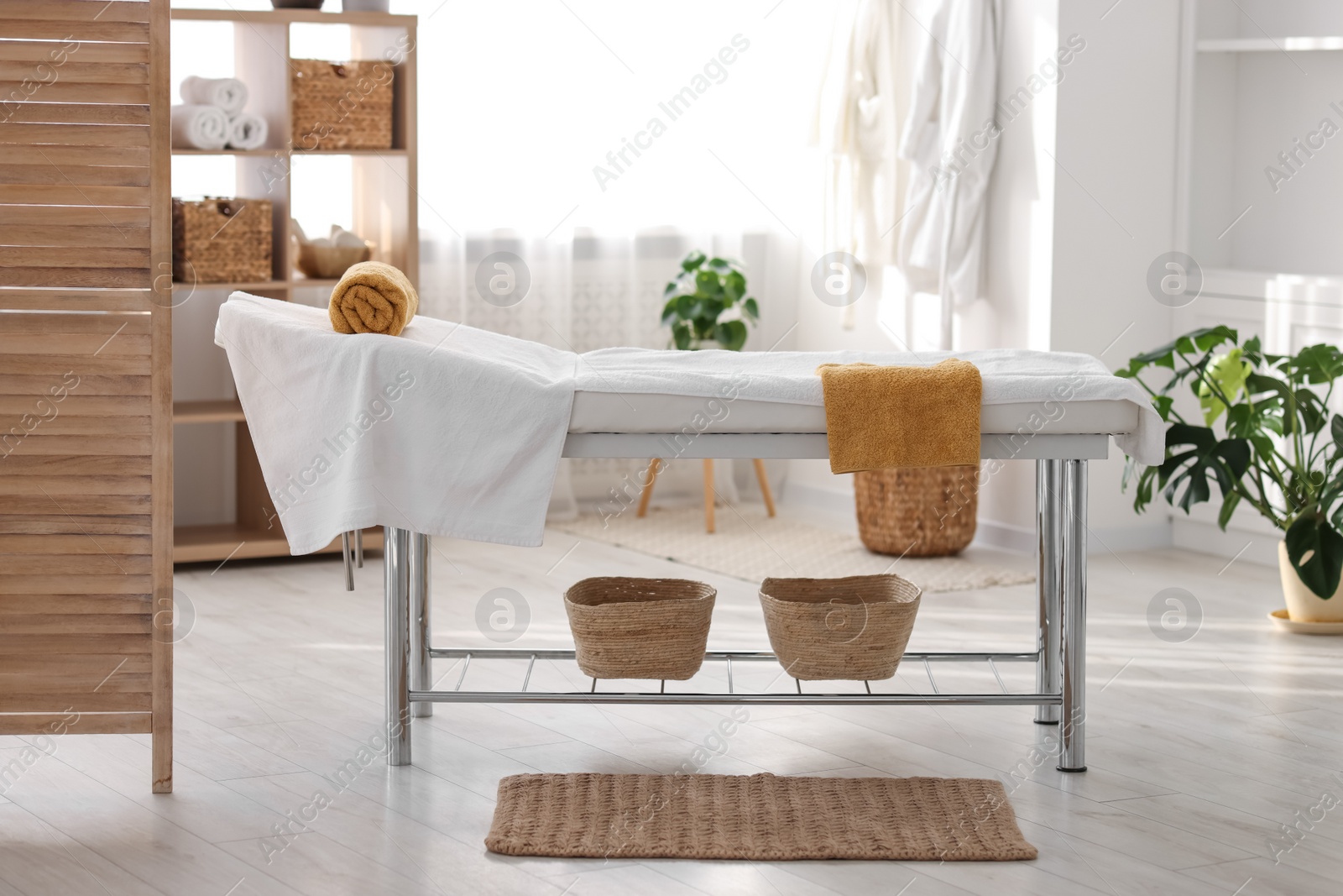 Photo of Comfortable massage table with clean towels in spa center