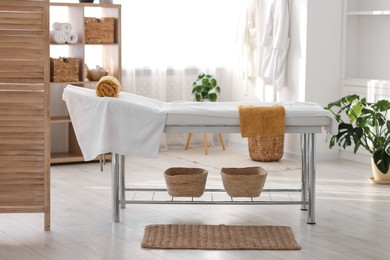 Comfortable massage table with clean towels in spa center