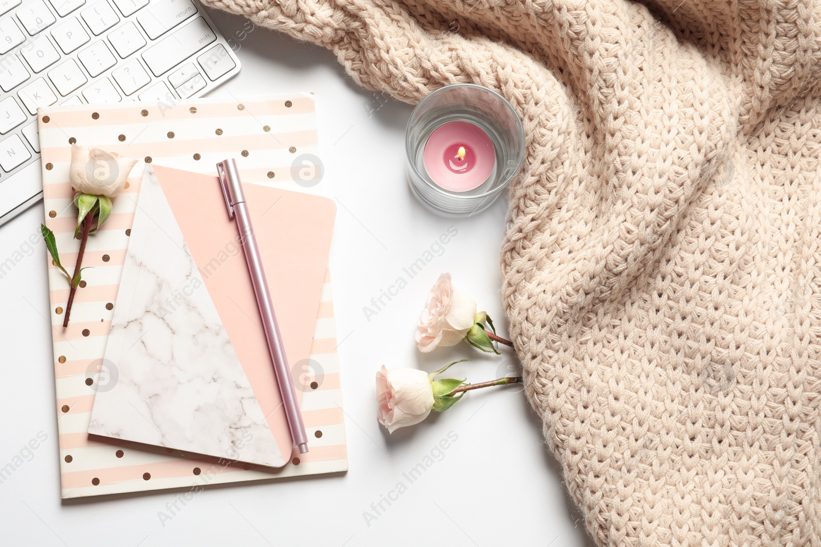 Photo of Flat lay composition with notebooks, warm blanket and computer keyboard on white background