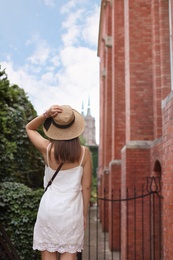 Photo of Young woman in stylish outfit on city street