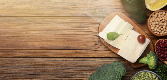 Image of Different vegan food products on wooden table, flat lay. Banner design with and space for text