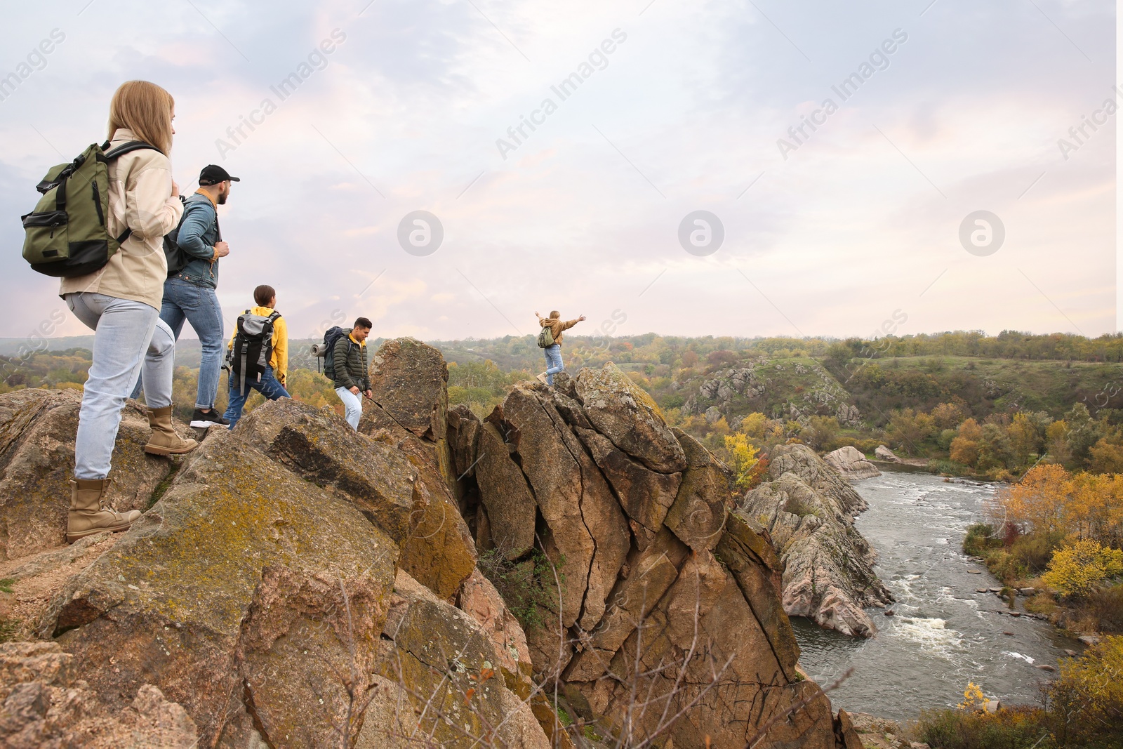 Photo of Group of hikers with backpacks at top of mountain