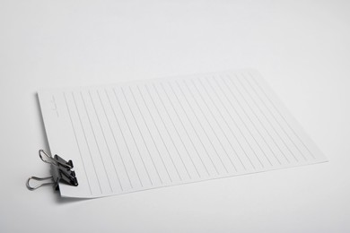 Photo of Sheet of paper with clip on white background