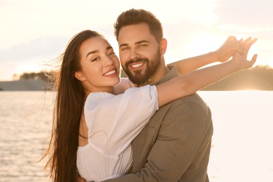 Photo of Portrait of happy couple near river on sunny day