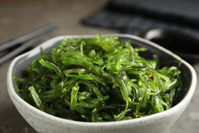 Photo of Japanese seaweed salad served on grey table, closeup