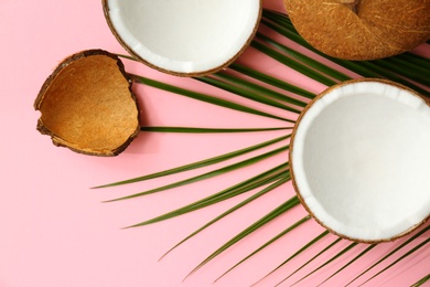 Photo of Fresh coconuts and palm leaf on pink background, flat lay