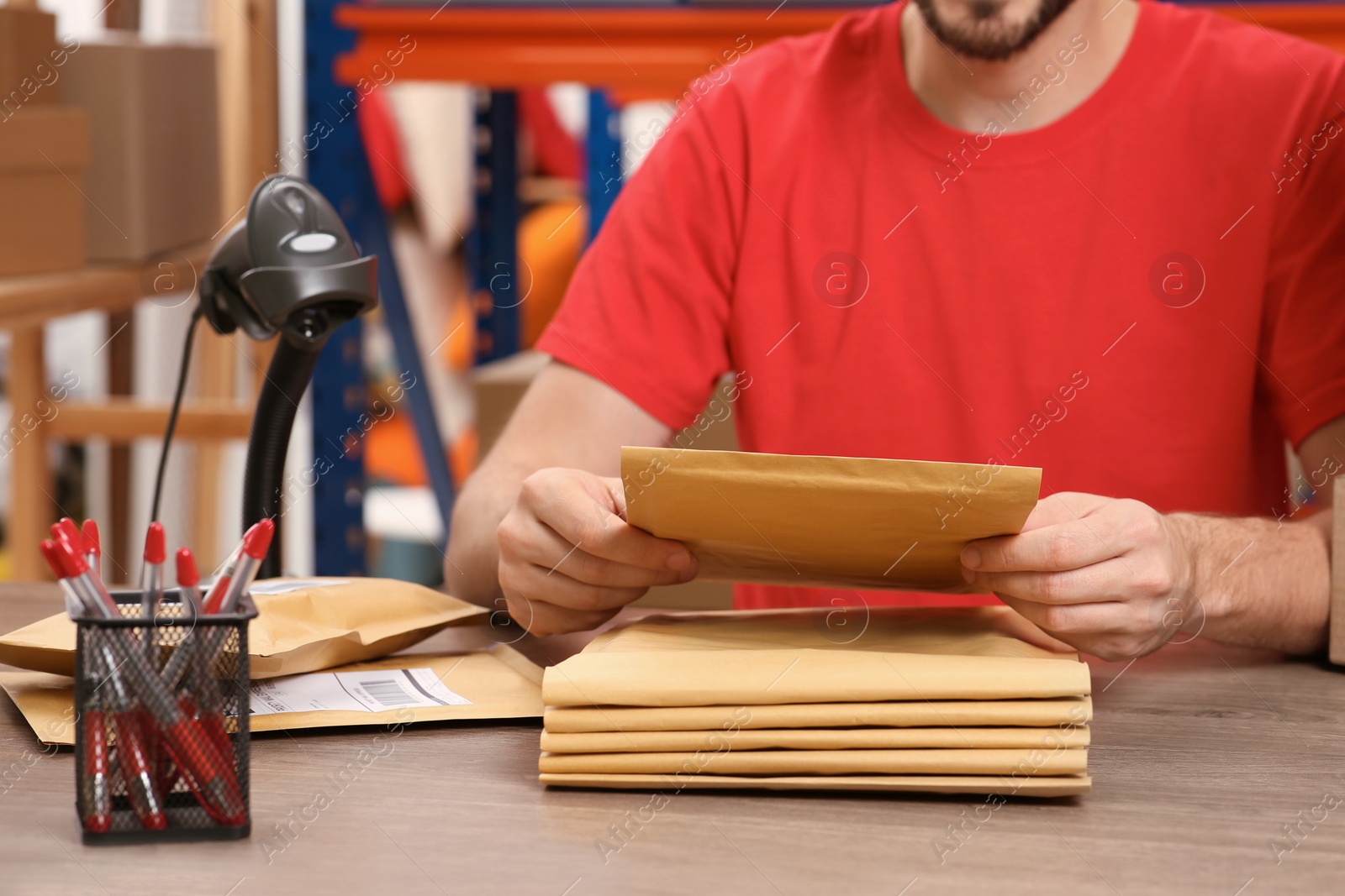 Photo of Post office worker with adhesive paper bags at counter indoors, closeup