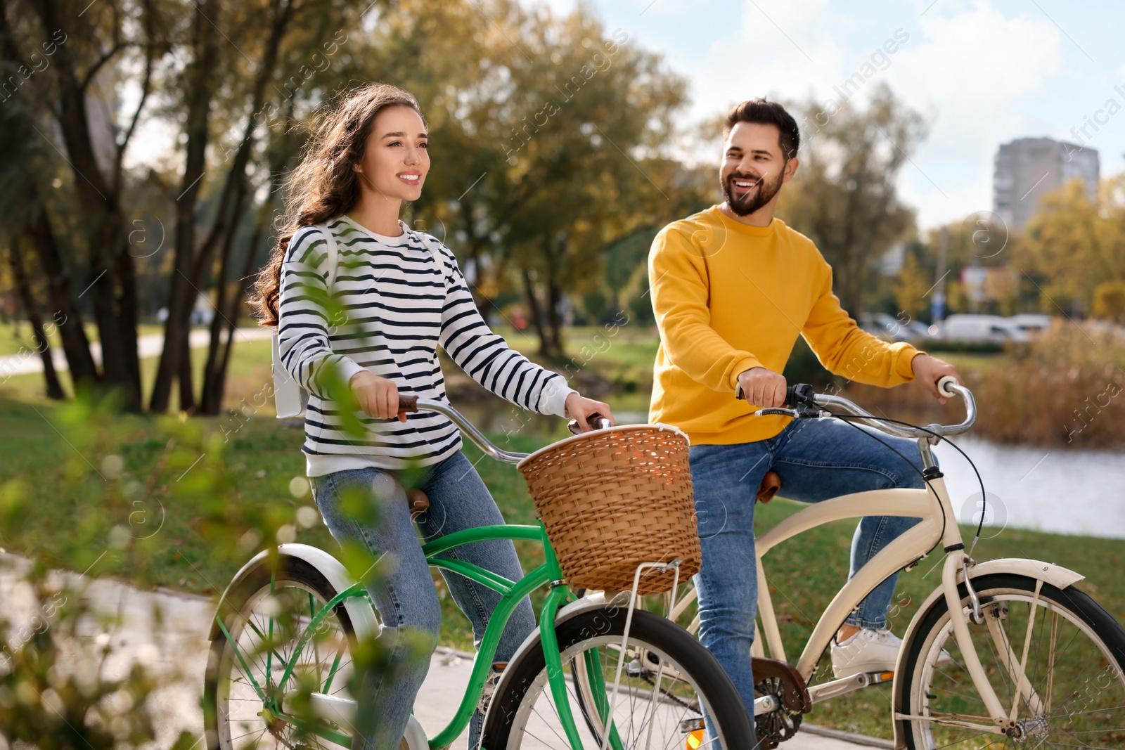 Photo of Beautiful young couple riding bicycles in park