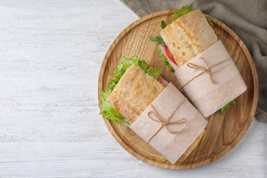 Photo of Tasty sandwiches with ham on white wooden table, top view