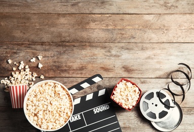 Flat lay composition with tasty popcorn and space for text on wooden background. Cinema snack