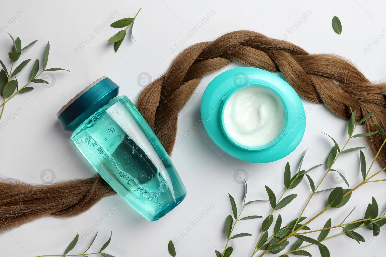Photo of Natural cosmetic products, green leaves and hair braid on white background, flat lay