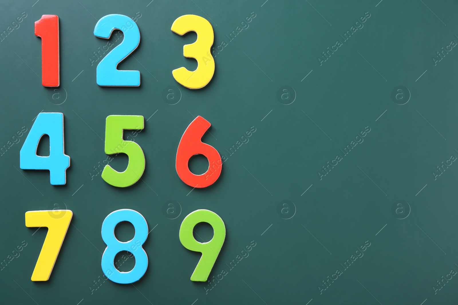 Photo of Colorful numbers on green background, flat lay. Space for text