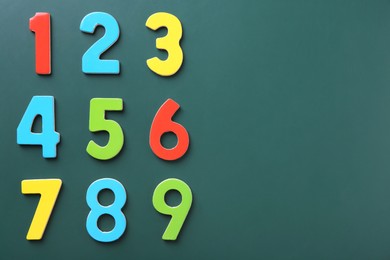 Photo of Colorful numbers on green background, flat lay. Space for text