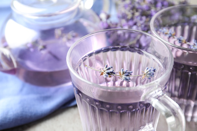 Photo of Fresh delicious drink with lavender in glass cup, closeup