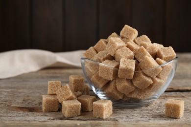 Photo of Brown sugar cubes on wooden table, closeup