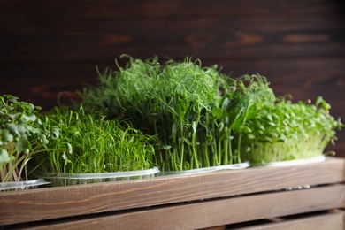Photo of Fresh different organic microgreens in wooden crate