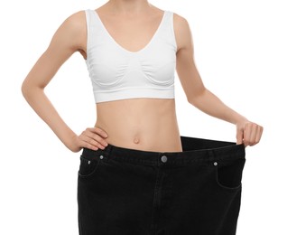 Young woman wearing big jeans after weight loss on white background, closeup