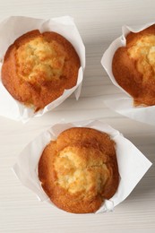 Tasty muffins on white wooden table, flat lay. Fresh pastry