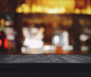 Image of Empty black wooden surface and blurred view of bar interior. Space for design