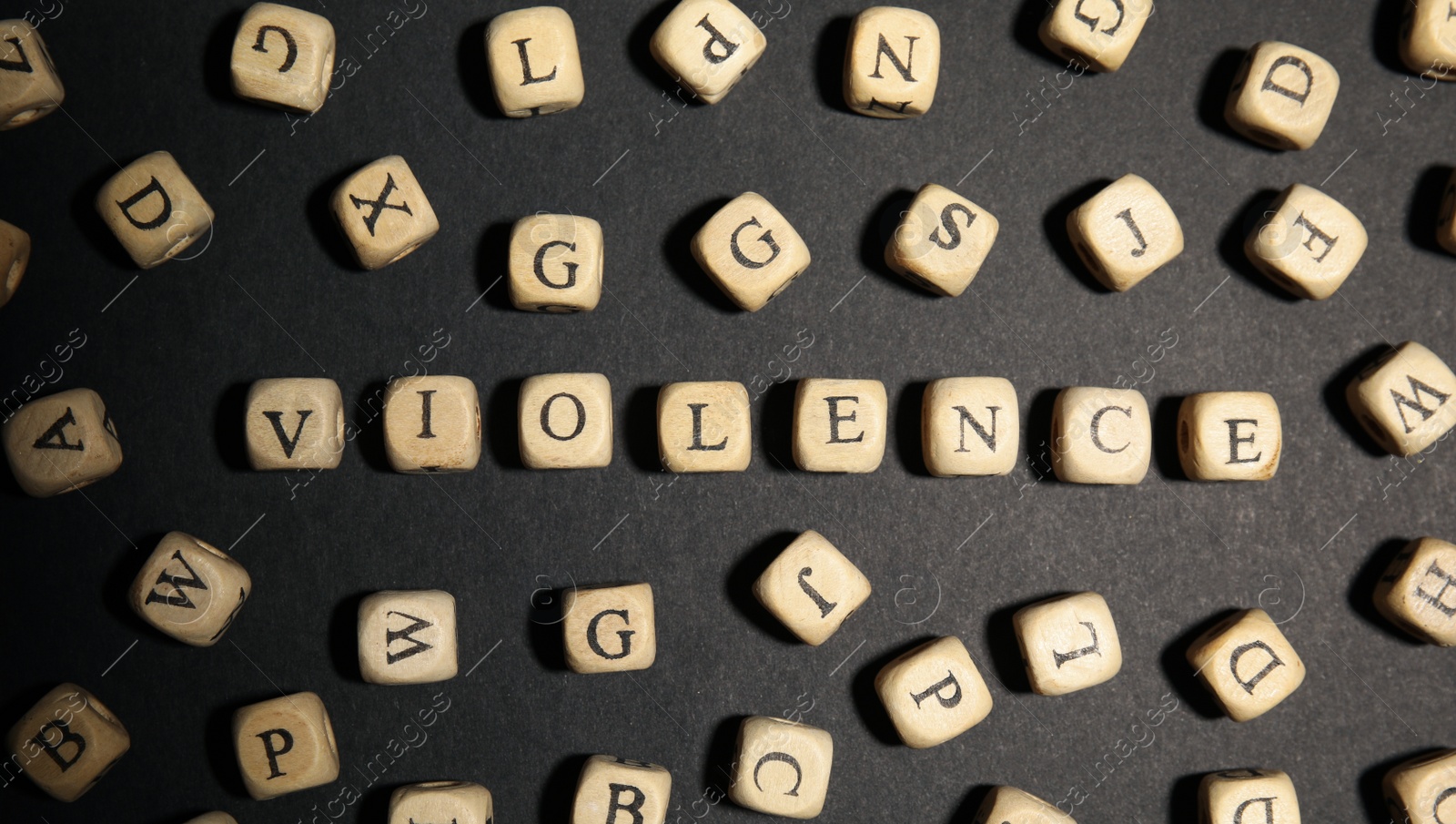 Photo of Word VIOLENCE made of wooden cubes on black background, flat lay