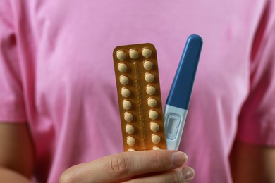 Photo of Woman holding birth control pills pregnancy test, closeup
