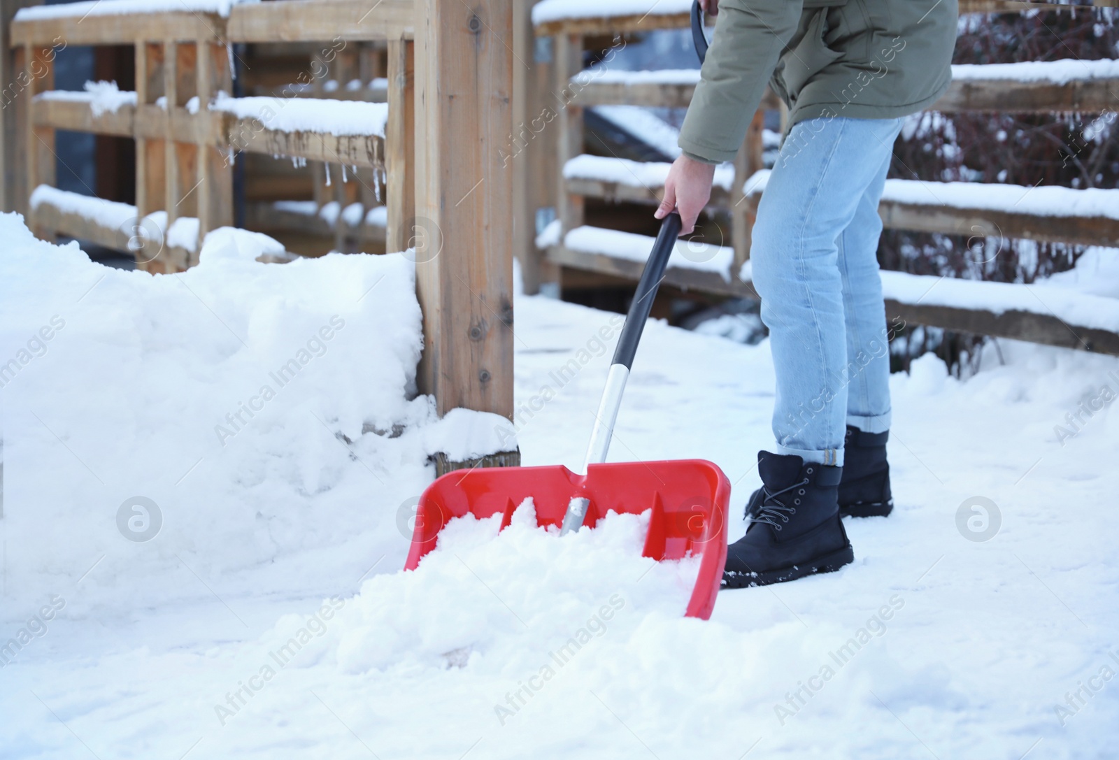 Photo of Man cleaning snow with shovel outdoors on winter day, closeup