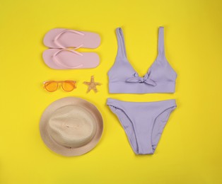 Flat lay composition with beach accessories on yellow background