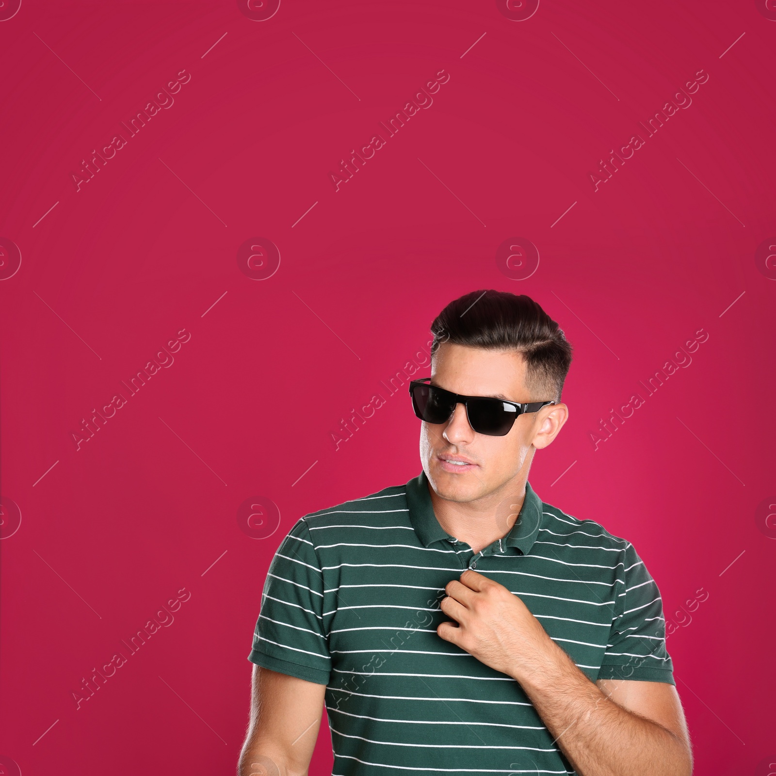 Photo of Handsome man wearing sunglasses on pink background