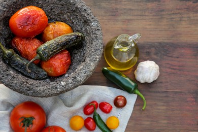 Ingredients for tasty salsa sauce and stone bowl on wooden table, flat lay