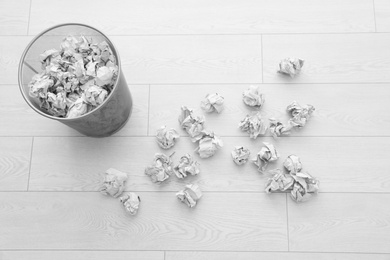 Metal bin and crumpled paper on floor, above view. Space for text