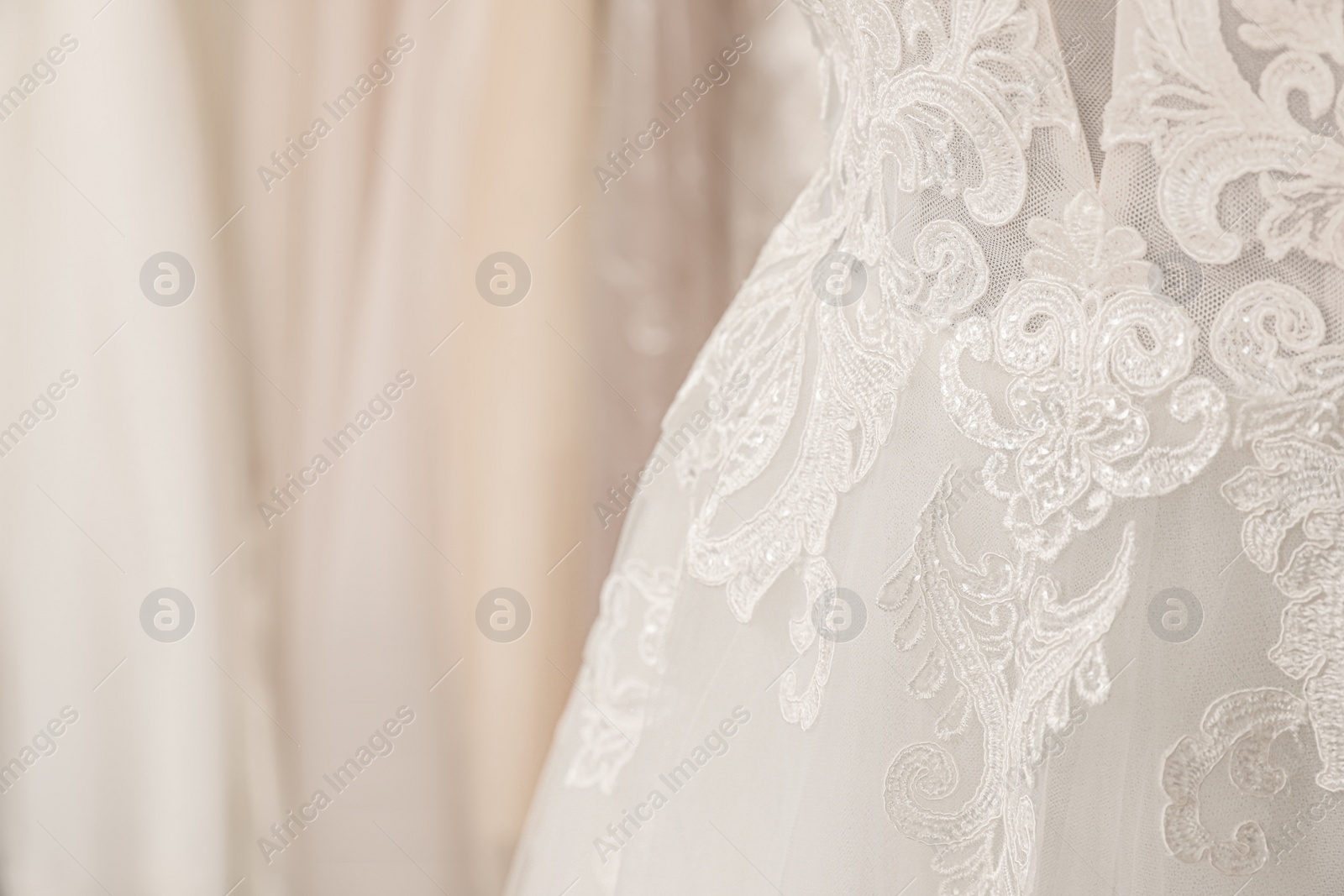 Photo of Beautiful wedding dress on mannequin in boutique, closeup