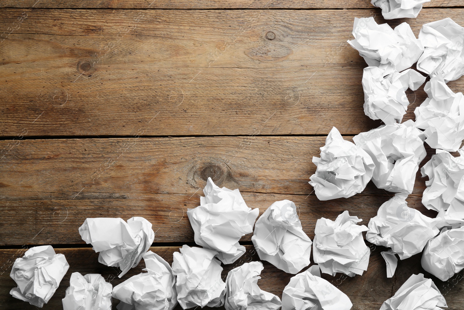 Photo of Crumpled sheets of paper on wooden background, flat lay. Space for text