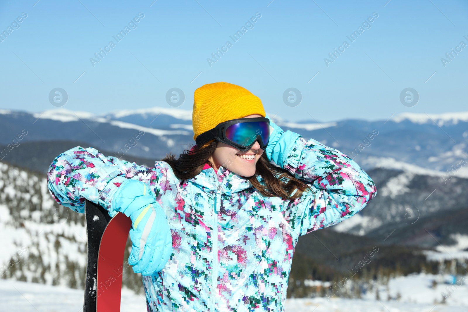 Photo of Young woman with ski equipment in mountains. Winter vacation