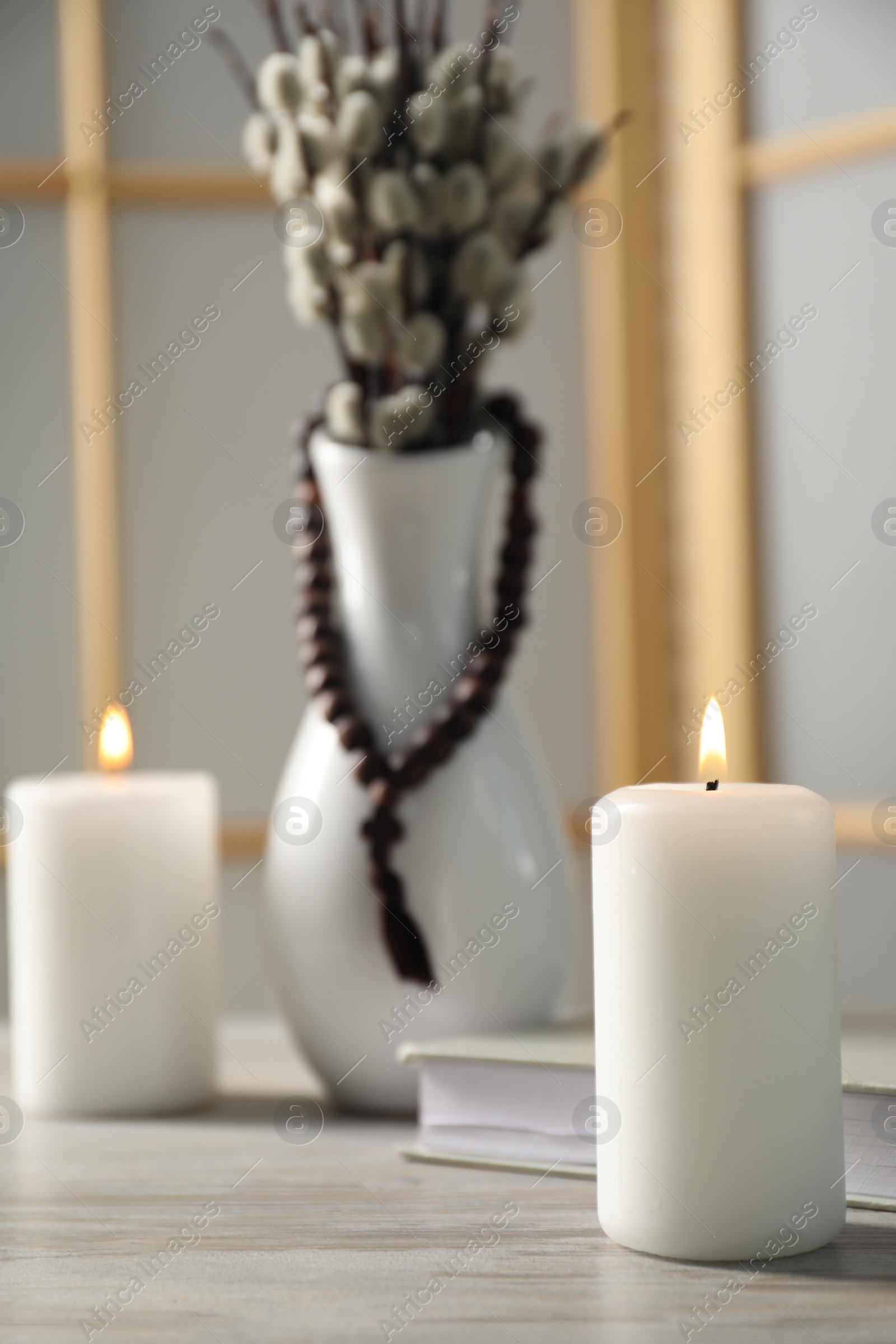 Photo of Burning candle on wooden table, closeup. Space for text